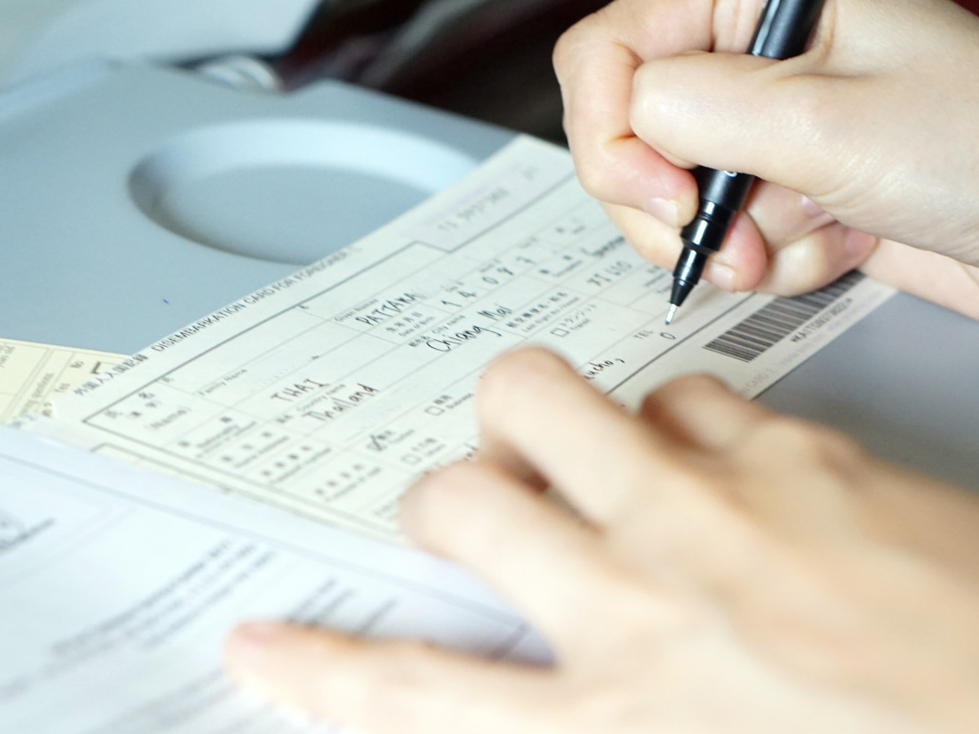 Compliazione del modulo d’immigrazione durante il volo