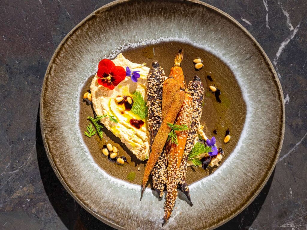 Carote di stagione con purea di ceci, thaina, semi di sesamo e spezie, una ricetta vegana ricca di vitamine