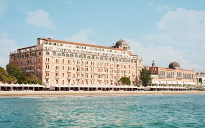 Il monumentale edificio dell'Hotel Excelsior Venice Lido con la prima fila di cabanas sulla spiaggia
