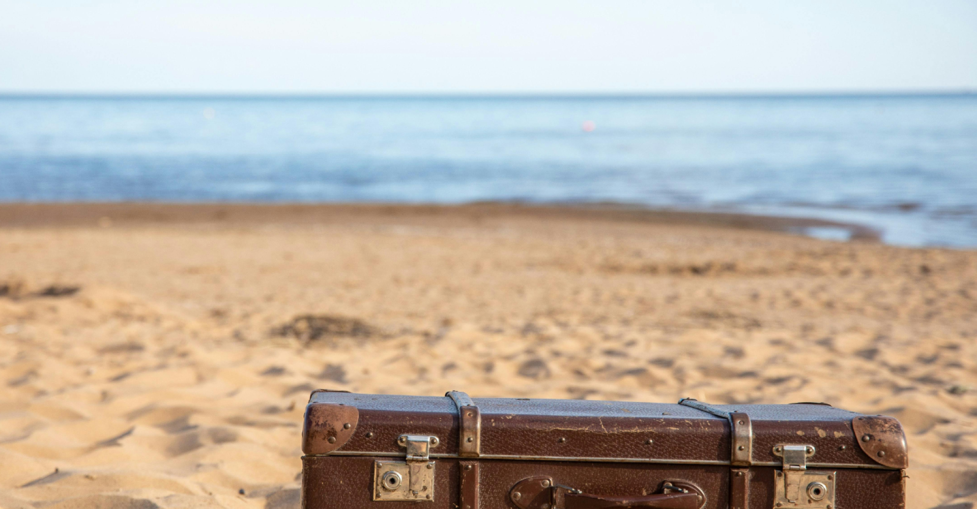 Una vecchia valigia abbandonata in spiaggia