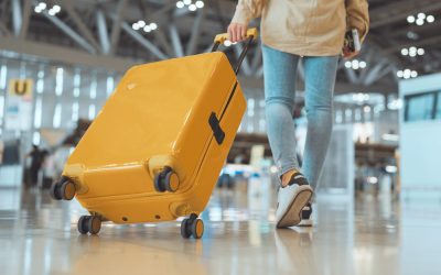 Passeggera con valigia nel moderno terminal dell’aeroporto.