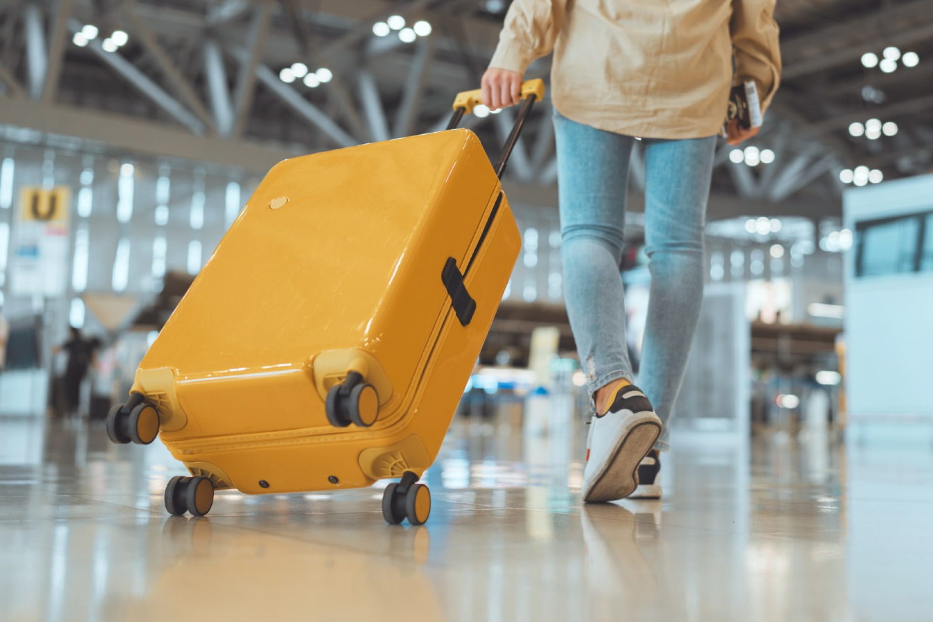 Passeggera con valigia nel moderno terminal dell’aeroporto.